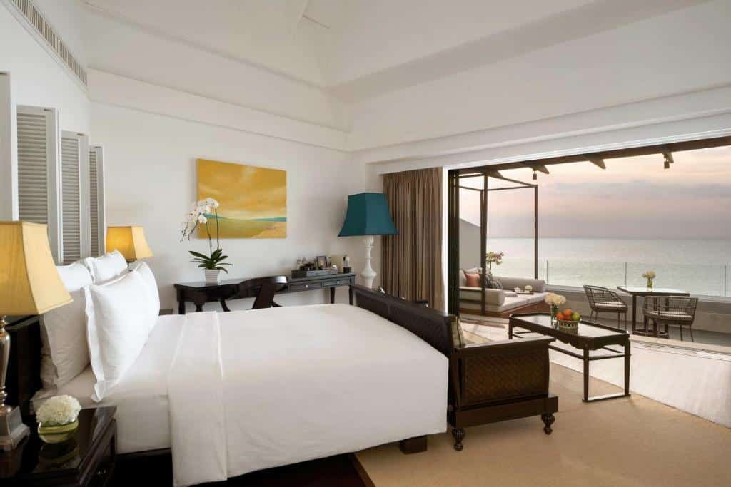 Quarto do InterContinental Koh Samui Resort com cama grande, escrivaninha e varanda com vista para o mar. O quarto tem decoração moderna e área de estar do lado de fora.