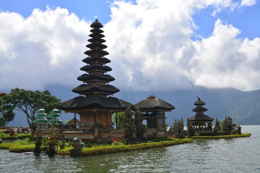 Vista do Pura Ulun Danu Bratan, um templo balinês em volta de um lago, que aparenta estar flutuando sobre a água.  Está ilustrando o post sobre o que fazer em Ubud.
