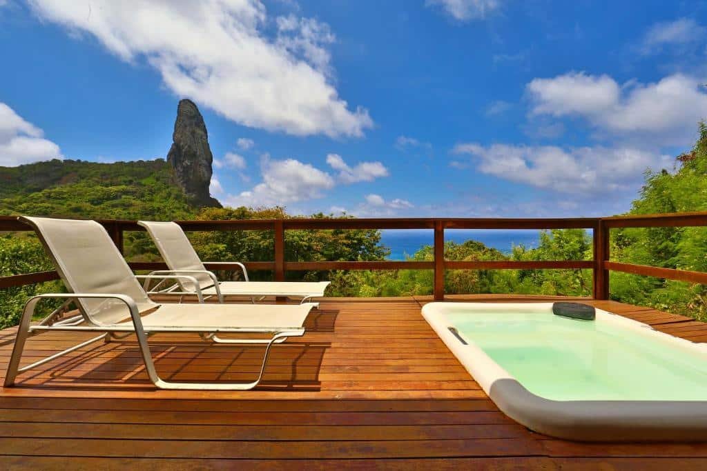 Deck de um dos bangalôs da Pousada Zé Maria com um banheira de hidro, duas espreguiçadeiras e uma bela vista para o mar e muita natureza